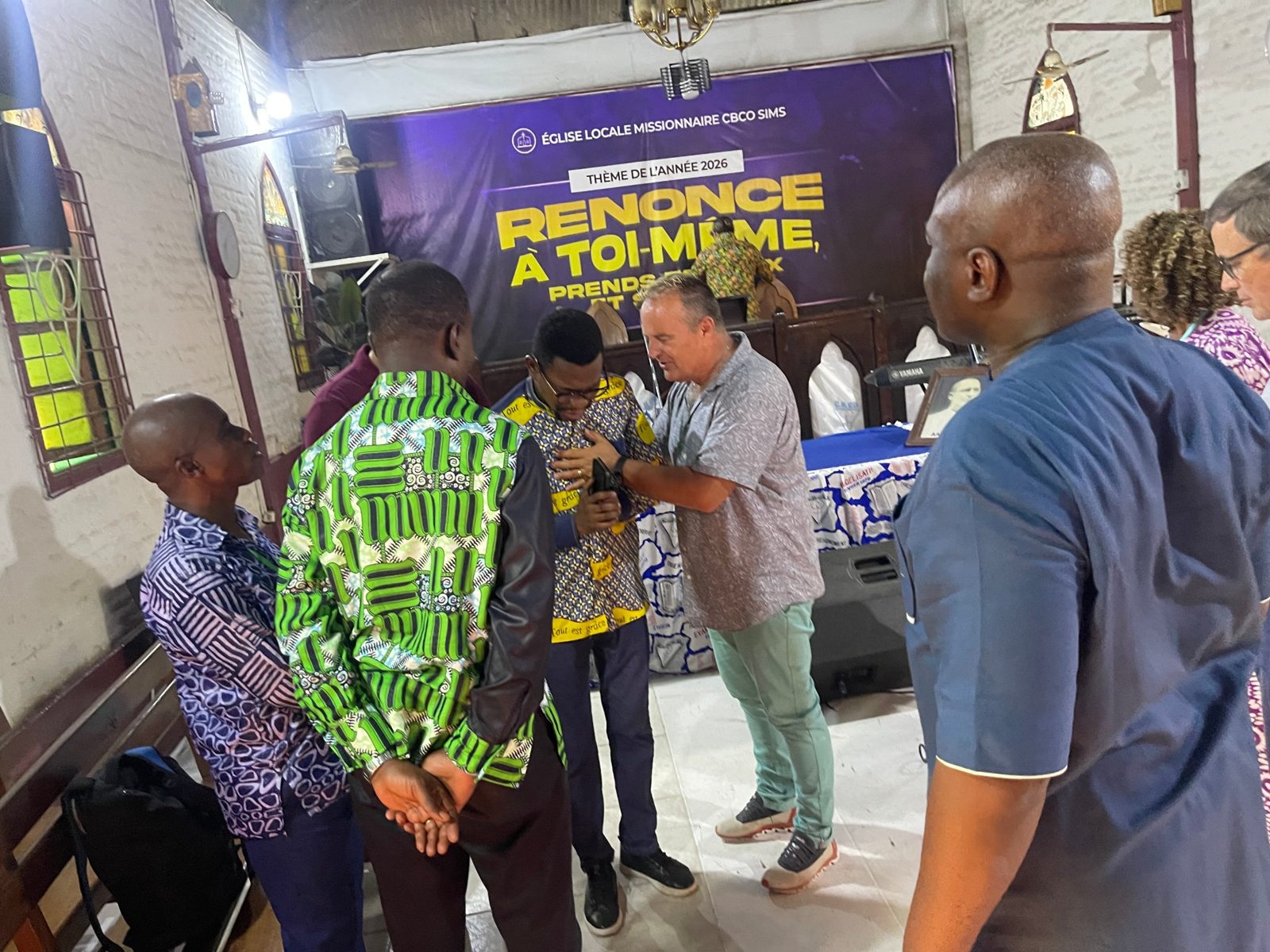 Team members praying for a pastor at the Sims church